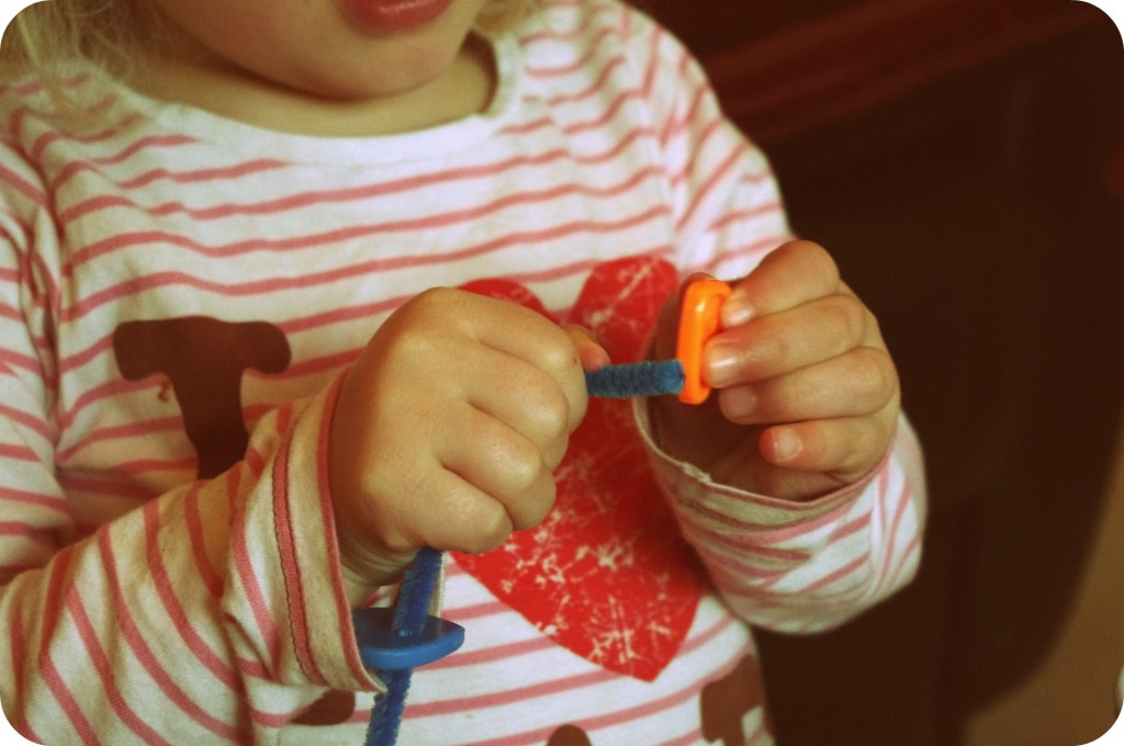 small hands small hands threading beads onto pipecleaners